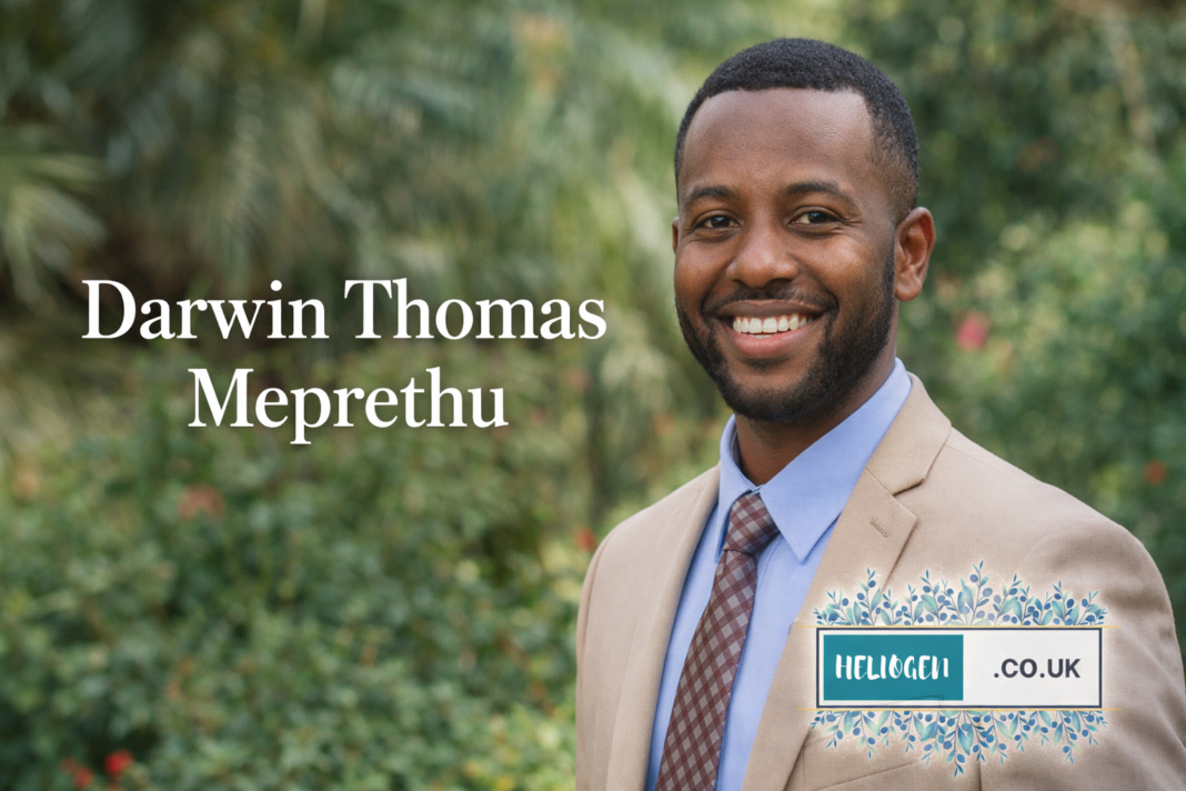 Darwin Thomas Meprethu smiling portrait in suit outdoors.